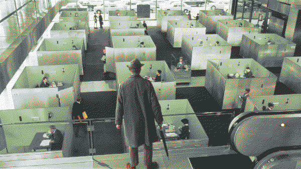 Still from the film PlayTime showing Monsieur Hulot looking down at a grid of modernist office cubicles