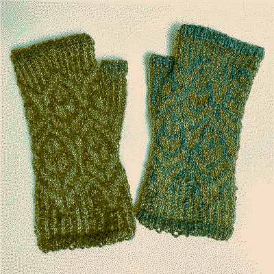A pair of knitted green wristwarmers with a leaf pattern